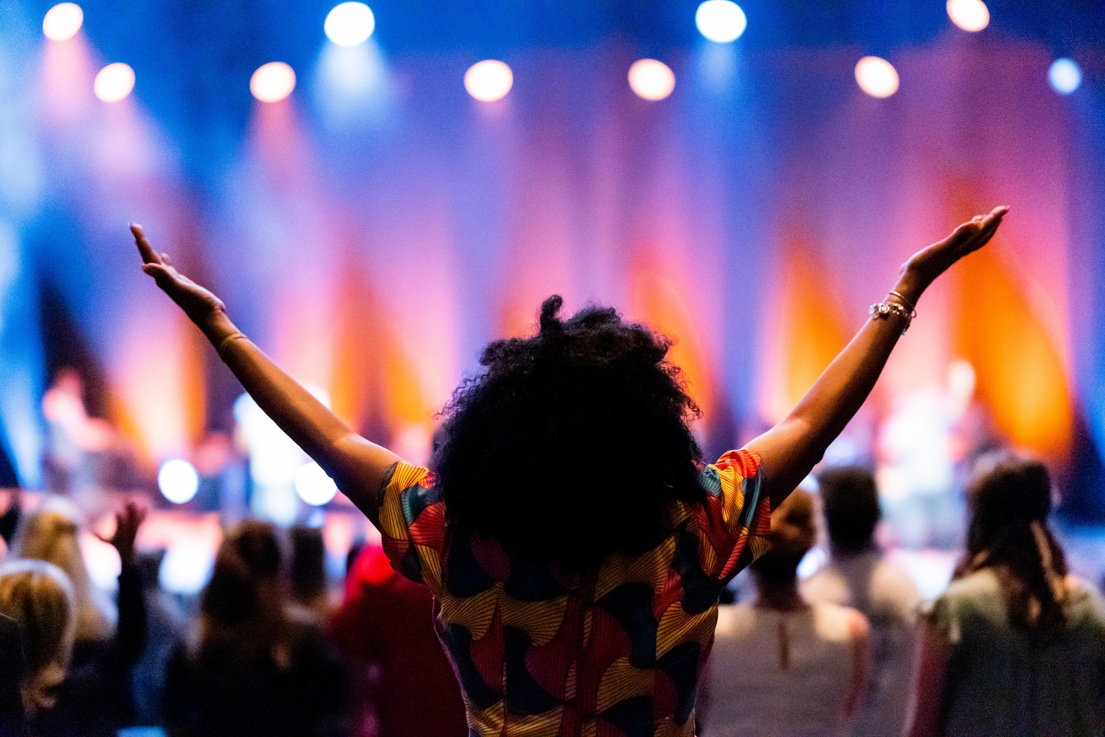 Unrecognizable black spectator enjoying concert in hall